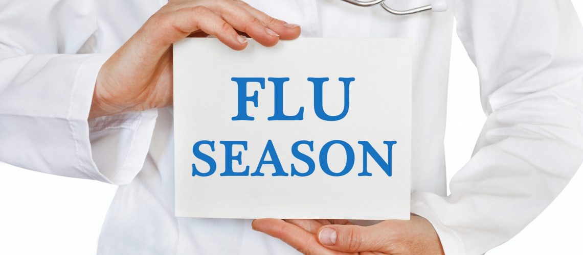 Doctor holding a card with Flu Season, medical concept