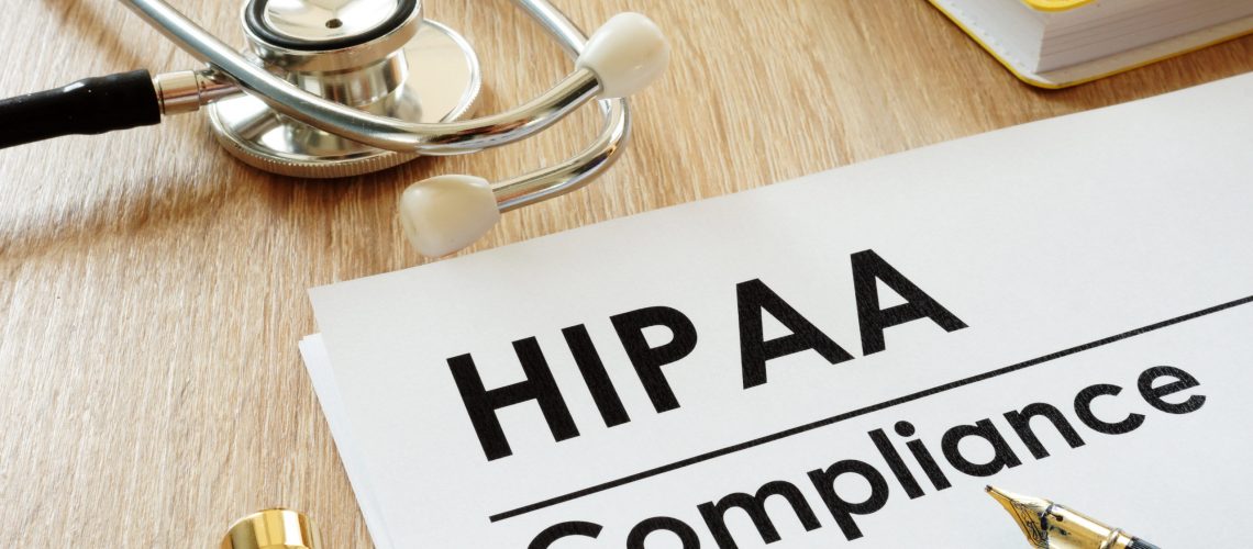 HIPAA Compliance application and stethoscope on a desk.