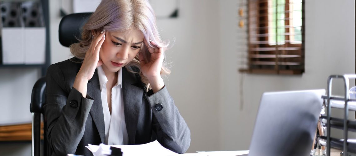 asian-businesswoman-are-serious-at-work-causing-headache-stressed-out-with-documents-with-a-laptop