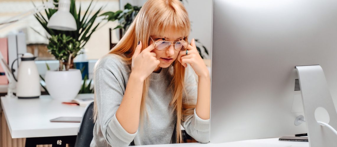 Overworked businesswoman working on desktop computer in office