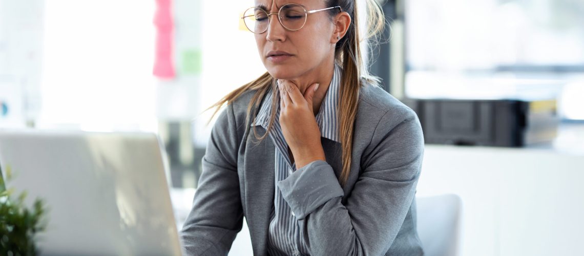 Illness young business woman with terrible throat pain working w