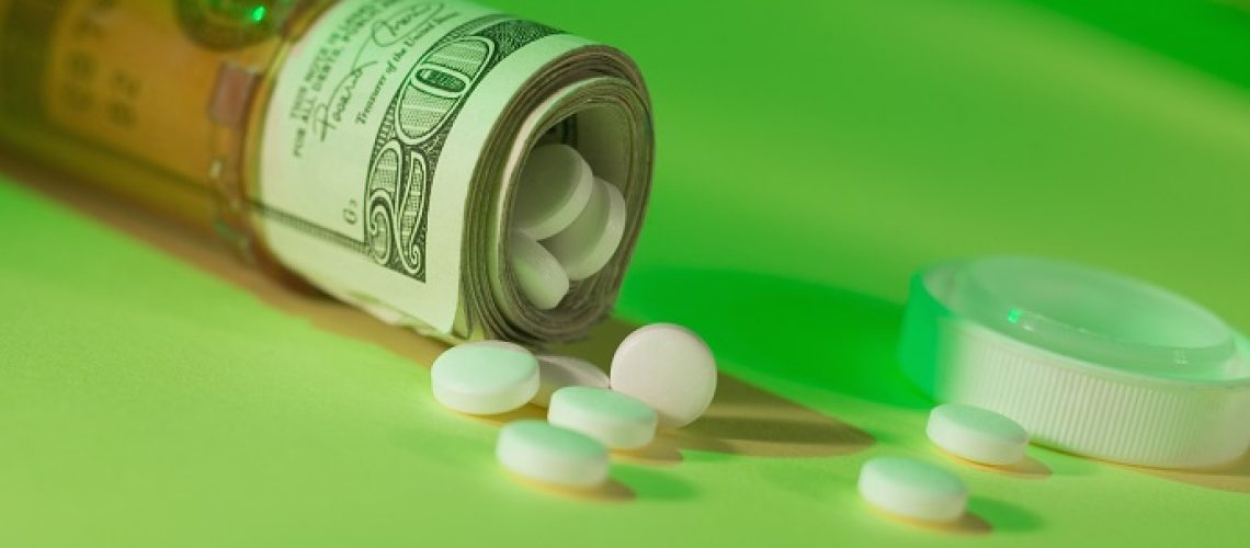 Dollar bills in pill bottle with medication